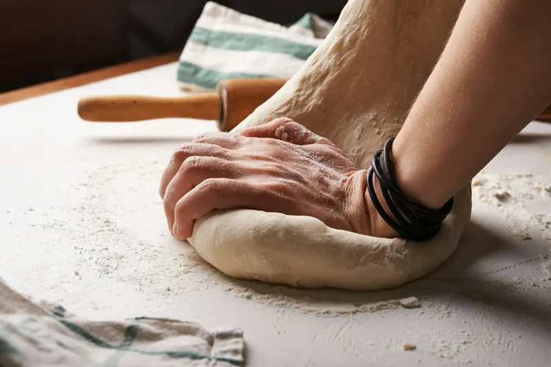 Hands kneading sourdough